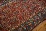 Detailed view of the pomegranate vine border and red cartouche field of a fine Kurdish Hamadan rug.