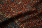 Angled close-up of the antique Hamadan rug's cartouche-like vines and interior boteh motifs.
