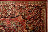 Vintage Sarouk carpet with dense floral spray in cherry red, black, and dusty teal.
