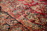 Dense hand-knotted Vintage Sarouk rug detail with cherry red floral spray and dusty teal.