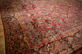 Vintage Sarouk carpet detail: cherry red field, slate blue border, intricate floral sprays and blossoms.