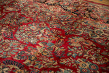 Detail of vintage Sarouk carpet: hand-knotted cherry red field, scrolling roses and vines.