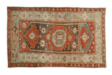 Vintage distressed Malayer rug with a geometric medallion in rust, charcoal, and soft powder blue.