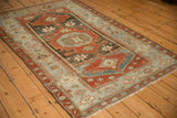 Angled perspective of the distressed vintage Malayer rug's traditional medallion and border layout.
