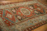 Angled detail of a distressed Malayer rug showing heavy abrashes in the powder blue field.