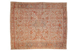 Vintage distressed Heriz carpet with geometric floral motifs in madder rust and dusty blue on an ivory field.