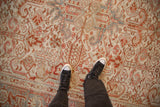 Close-up of the distressed, low-pile texture of a vintage Heriz Persian carpet shown underfoot.