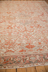 Angled view along a vintage Heriz carpet, highlighting the expansive field of geometric floral blossoms and worn texture.