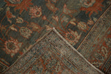 A folded corner of the vintage Persian carpet reveals its hand-knotted foundation and abrashed pile.