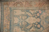 Evenly worn pile showing the arabesque floral border in dusty teal, sand, and pink.