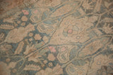 Close-up on the even wear and knot heads of a vintage Bijar with teal and pink floral patterns.