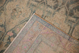 A vintage Bijar rug corner folded back to reveal the hand-knotted foundation and low pile.
