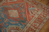 Angled view of the worn texture and geometric corner on a vintage Persian rug.