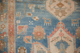 Close-up of a geometric animal motif on the sky blue field of a distressed hand-knotted Persian rug.