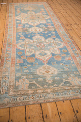 Perspective view of a distressed antique runner's sky blue field and repeating geometric medallions.