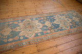 Angled view of the geometric starburst medallions on a distressed antique Persian runner.