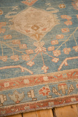 Textured low pile of an antique Persian runner with geometric patterns in blue, ivory, and terracotta.