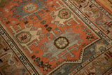Distressed vintage Malayer rug detail: terracotta field, ram's horn palmettes, serpent border.