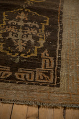 Geometric cloudband design in the coffee brown spandrel of an antique Tibetan rug.