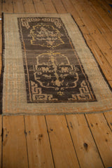 Antique Tibetan rug seen from a low angle, highlighting the full geometric design and earthy brown tones.