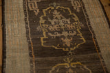Visible knot heads and low pile on the oxidized silver border of an antique Tibetan rug.