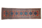 Antique Northwest Persian runner with a column of dusty teal and navy medallions on a rich brick red ground.
