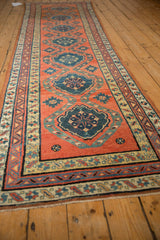 Angled perspective showing the repeating single-column medallions of an antique Persian runner.