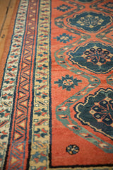 Angled close-up on the antique runner's pile, showing its geometric border and teal medallions.