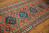 A perspective view down the antique Persian runner, showing the column of teal medallions.