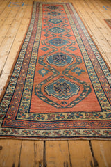 Angled view of an antique Northwest Persian runner's repeating column of central medallions.