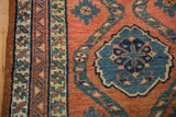 Floral blossom medallion and ivory border detail on a brick-red antique Northwest Persian runner.