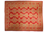 Vintage Oushak carpet with a cherry red field and columnar medallions in saffron yellow and sky blue.