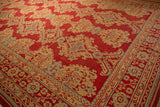 Angled view of the quatrefoil and diamond medallions on a vintage Oushak carpet.