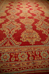 Low-angle view of the vintage Oushak carpet's hand-knotted pile and detailed border.