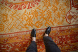 Antique Oushak carpet with textured pile, saffron yellow and tangerine nuanced floral patterns.