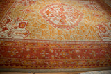 Madder root red border with gold and tangerine floral motifs on an antique Oushak rug.