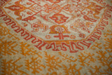 Tangerine and gold nuanced floral motifs with flame-like details on seafoam green antique Oushak pile.
