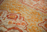 Detail of antique Oushak carpet showing hand-knotted pile with nuanced saffron and madder red floral motifs.