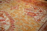 Nuanced floral rendering of flame-like blossoms on antique Oushak carpet in saffron yellow and seafoam green.