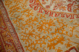 Antique Oushak carpet, tangerine floral elements on dusty seafoam green with madder red border.