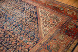 Intricate madder root red arabesque border and navy blue floral field on a Vintage Mahal carpet.