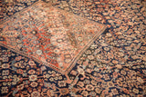 Intricate floral lattice in navy, dusty rose, and beige with visible abrash and patina.