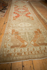 Full length perspective of the vintage distressed Malayer runner with its repeating medallion design.