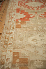 Angled detail of the distressed low pile, showing the terracotta and beige geometric border.