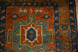 Close-up on the hexagonal medallion and starburst border of the antique Persian Heriz rug.