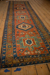 Angled view of an antique Heriz runner, showcasing its full length and column of geometric medallions.