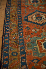 Colorful starburst and floral borders in sapphire blue, gold, and terracotta on an antique Heriz runner.