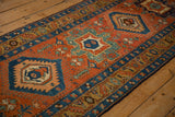 Angled view of an antique Heriz runner showing its textured pile and alternating geometric medallions.