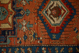 Hexagonal medallion and geometric buds in sapphire and jade on a madder red antique Heriz rug.