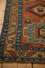 Antique Heriz rug corner showing the textured pile and borders with starburst and floral motifs.